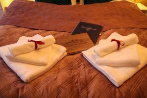 duas toalhas em cima de uma cama com um cartão em Apartment Serenade am Zwinger em Goslar