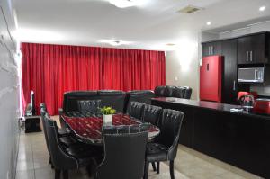 een eetkamer met een rood gordijn en een tafel en stoelen bij Accommodation Front - Deluxe 6 Sleeper with Rooftop Pool in Durban