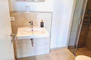 a bathroom with a sink and a shower at Lovely New Studio in Kirchberg - G in Luxembourg