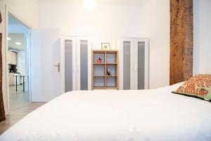 a bedroom with a white bed and a book shelf at FAMILIAS Y GRUPOS - Muy buena UBICACION - BILBAO in Bilbao