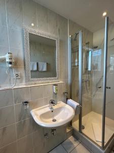 a bathroom with a sink and a shower at Hotel Arkade in Leverkusen