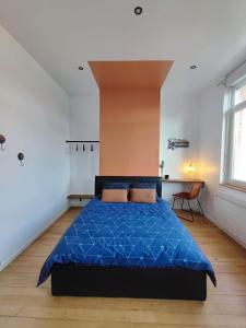 a bedroom with a bed with a blue comforter at Le Relax in Albert