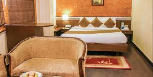 una camera d'albergo con letto e sedia di Hotel O2 VIP a Calcutta