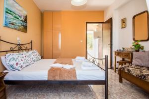 a bedroom with a bed and a chair in a room at Aristotelis Apartments in Razáta