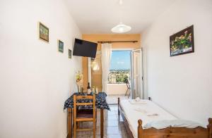 a room with a bed and a table and a window at Aristotelis Apartments in Razáta