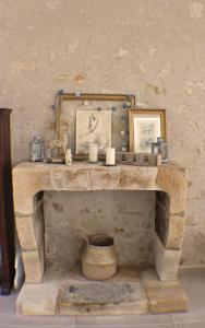 d'une cheminée en pierre avec deux photos et des bougies. dans l'établissement Le Domaine des Cyclamens, à Verneuil-sur-Indre