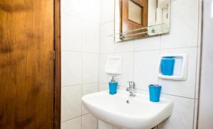 Un baño con lavabo con tazas azules. en Aristotelis Apartments en Razáta