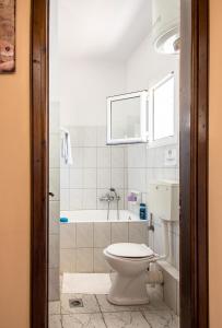 łazienka z toaletą i wanną w obiekcie Aristotelis Apartments w mieście Razáta