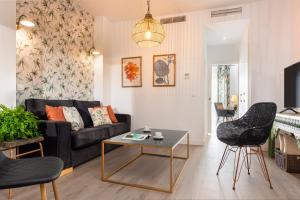 una sala de estar con un sofá y una mesa en Casa Triana 1888 Suites by Época, en Sevilla