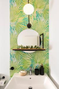 a bathroom with a mirror and a white sink at Casa Triana 1888 Suites by Época in Seville