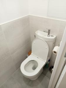 La salle de bains est pourvue de toilettes blanches. dans l'établissement WIFI- STADE DE FRANCE- BASILIQUE CATHEDRALE MONSEJOURASAINTDENIS, à Saint-Denis