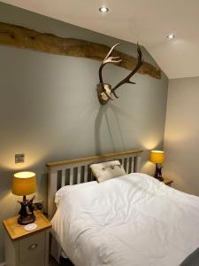 a bedroom with a bed with a antler on the wall at ‘The Retreat” at the Rose @ Crown 