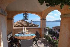 a table on a balcony with a view of the water at villa fronte mare in Cannigione