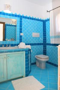 a blue tiled bathroom with a toilet and a sink at villa fronte mare in Cannigione