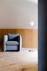 a living room with a blue chair and a lamp at Kai 36 - Hotel zwischen Fels und Fluss in Graz