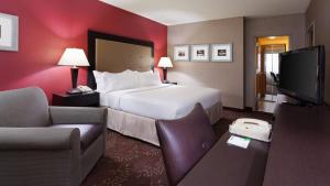 Holiday Inn Cincinnati Airport, an IHG Hotel في إيرلانغر: غرفة فندقية بسرير وتلفزيون بشاشة مسطحة