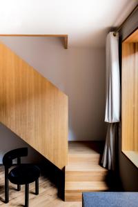 a room with a staircase with a chair and a table at Kai 36 - Hotel zwischen Fels und Fluss in Graz