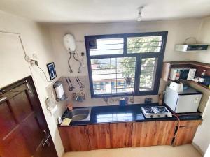 a small kitchen with a sink and a window at Meraki - Entire 2BHK Villa With Himalayan Views in Rānīkhet