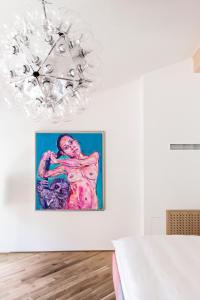 a painting on a wall in a room with a chandelier at Kai 36 - Hotel zwischen Fels und Fluss in Graz