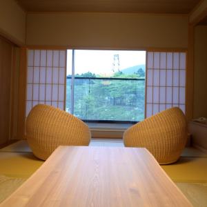 1 mesa y 2 sillas en una habitación con ventana en Hakone Gora Byakudan, en Hakone