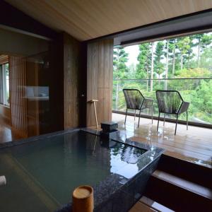 a living room with a large glass table and chairs at Hakone Gora Byakudan in Hakone