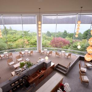 箱根町にある箱根強羅　白檀のテーブルと椅子、大きな窓が備わる広い客室です。