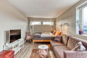 uma sala de estar com um sofá e uma cama em Stockholms home away from home em Estocolmo