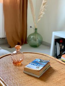 un libro y una botella de vidrio sobre una mesa en Appartements Le Tilleul de la Vallée Noble, en Westhalten