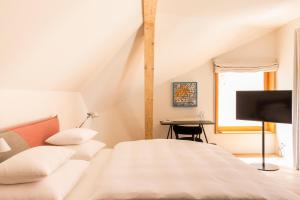 a bedroom with a bed and a desk at Kai 36 - Hotel zwischen Fels und Fluss in Graz