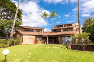 een exterieur van een huis met palmbomen bij Kuleana Resort 207 in Kahana