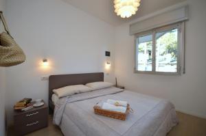 sypialnia z łóżkiem i koszem na nim w obiekcie Villa Gloria w Lignano Sabbiadoro