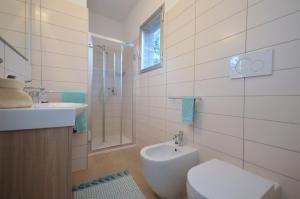 łazienka z toaletą i umywalką w obiekcie Villa Gloria w Lignano Sabbiadoro