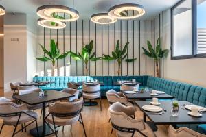 restauracja ze stołami, krzesłami i roślinami w obiekcie Amario Suites Hotel w mieście Ejo