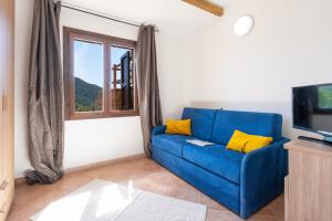 un divano blu in soggiorno con finestra di Residence La Falata Costa Paradiso a Costa Paradiso