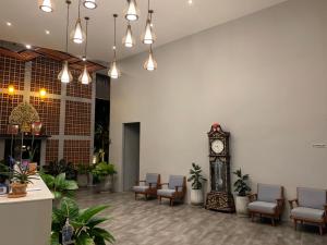 a lobby with a clock in the middle of a room at Atom Phuket Hotel -SHA Plus in Nai Yang Beach