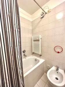 ein Badezimmer mit einer Badewanne und einem Waschbecken in der Unterkunft Bilocale Green in Madonna di Campiglio