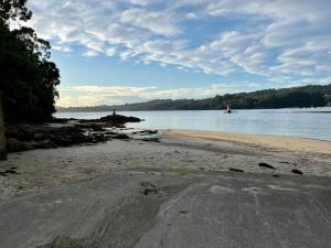 una playa con un cuerpo de agua y un cielo nublado en Acogedor estudio en Pontedeume, en Puentedeume