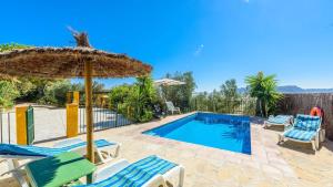 - une piscine avec des chaises et un parasol dans l'établissement Huerta La Lapa Cañete la Real by Ruralidays, à Cañete la Real