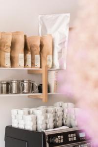 a kitchen with a shelf of cups and a microwave at Kai 36 - Hotel zwischen Fels und Fluss in Graz