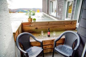 einen Tisch mit 2 Stühlen und eine Flasche Wein auf dem Balkon in der Unterkunft Smart Resorts Haus Saphir Ferienwohnung 505 in Winterberg
