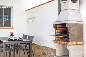 a stone fireplace in a dining room with a table and chairs at Casa Pablo in Conil de la Frontera