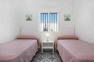 due letti in una stanza con finestra di Casa Pablo a Hozanejos Altre 18 foto