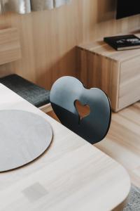 een zwart hartvormig item zittend op een tafel bij HALWINA Hideaway in Sibratsgfäll