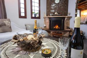 ein Wohnzimmer mit einem Tisch und einer Flasche Wein in der Unterkunft Casa Rita ΛΟΥΤΡΑ ΠΟΖΑΡ ΑΡΙΔΑΙΑ in Aridea