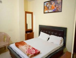 een slaapkamer met een bed met een spiegel aan de muur bij Hotel Goyal, Mansa in Mānsa