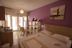 a bedroom with a white bed and a purple wall at Apartment Antonio in Jezera