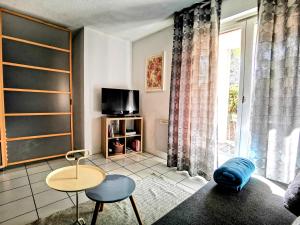 uma sala de estar com uma mesa e uma televisão em La Bulle Bleue - Parking-Terrasse-aéoport-MEET em Blagnac