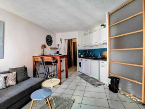 a living room with a couch and a kitchen at La Bulle Bleue - Parking-Terrasse-aéoport-MEET in Blagnac