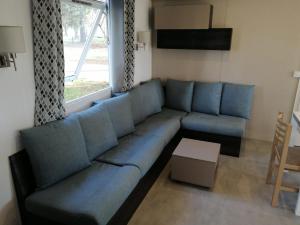 a blue couch in a living room with a window at Mobilhome 6/8 personnes Piriac sur Mer in Piriac-sur-Mer