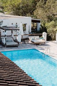 a swimming pool with blue water in front of a house at Can Vistabella Boutique Resort in San Antonio